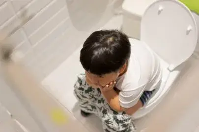 Potret anak duduk di toilet sebelum mencoba obat sakit perut anak